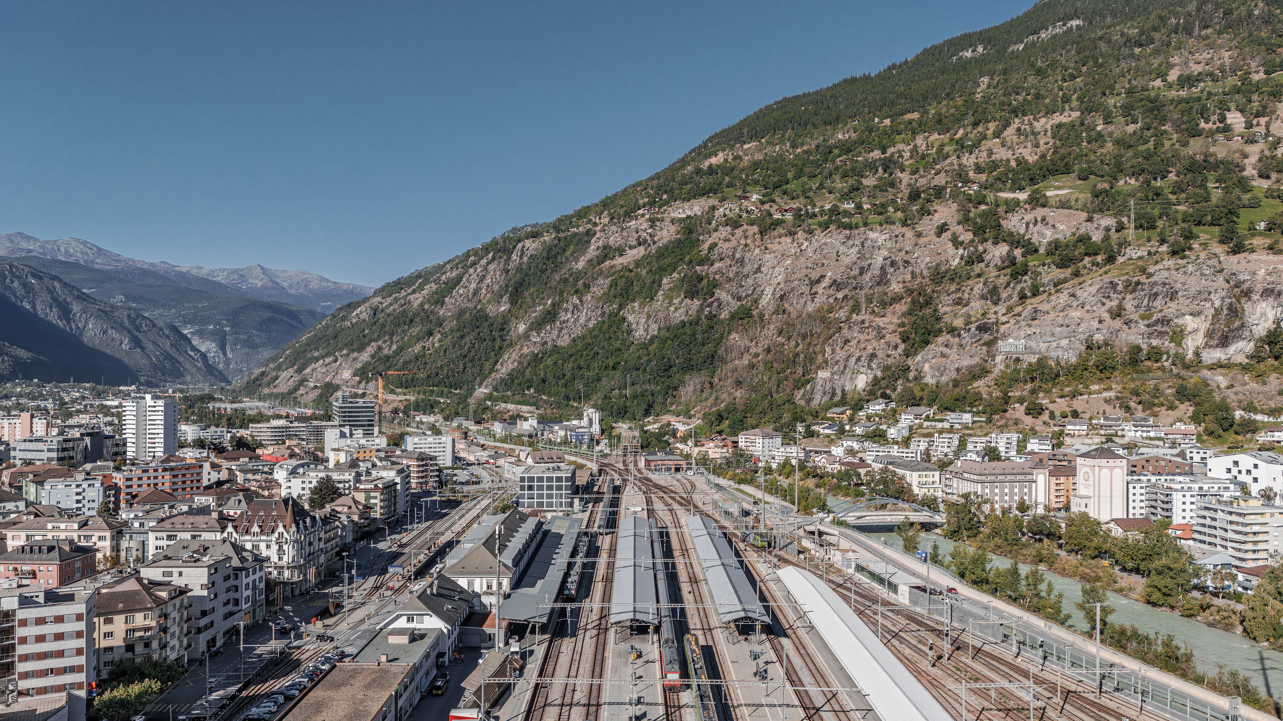 Blick von oben auf die Gleise und Perrons des Bahnhofs Brig.