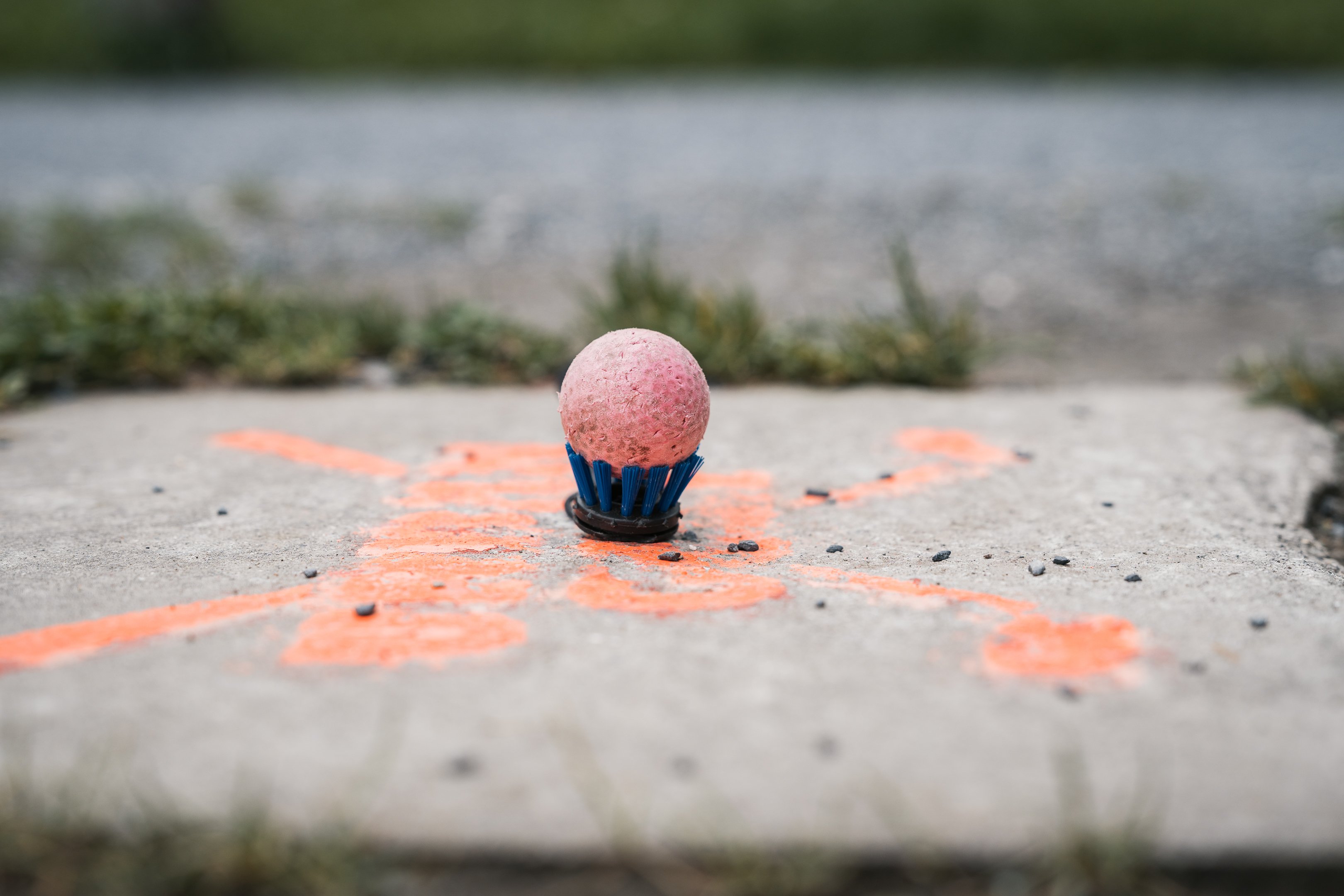 Golfball in einer Halterung am Boden.