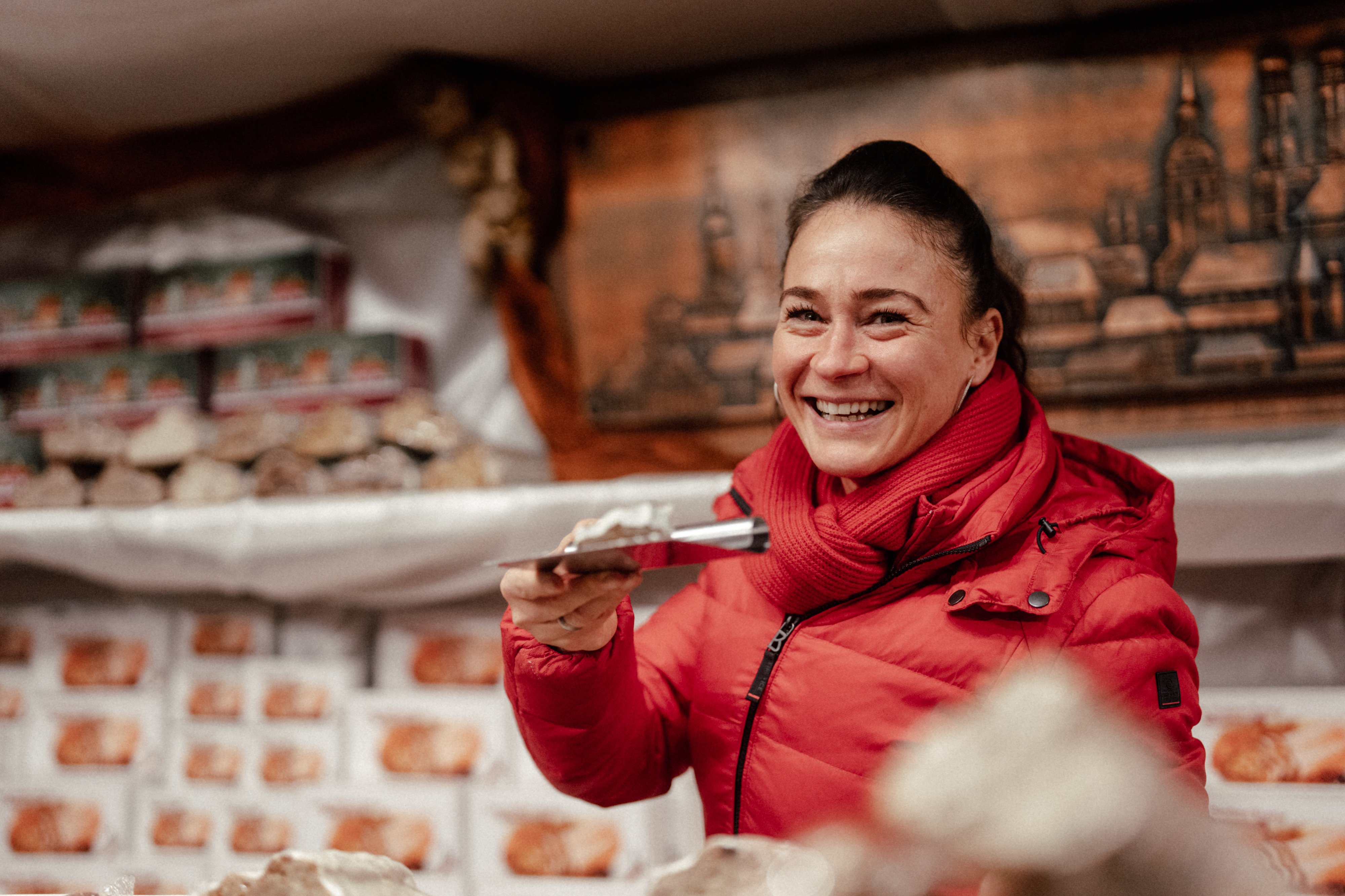 Verkäuferin verkauft Christstollen aus einem Stand am Münchner Christkindlmarkt.
