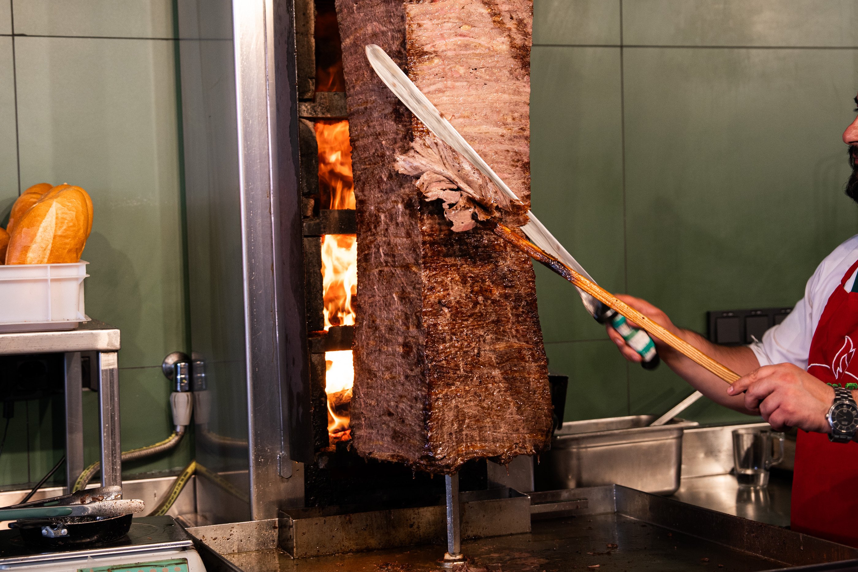 Un employé de Ferhat Döner découpe la viande de bœuf issue des pâturages autrichiens sur la broche à kebab.