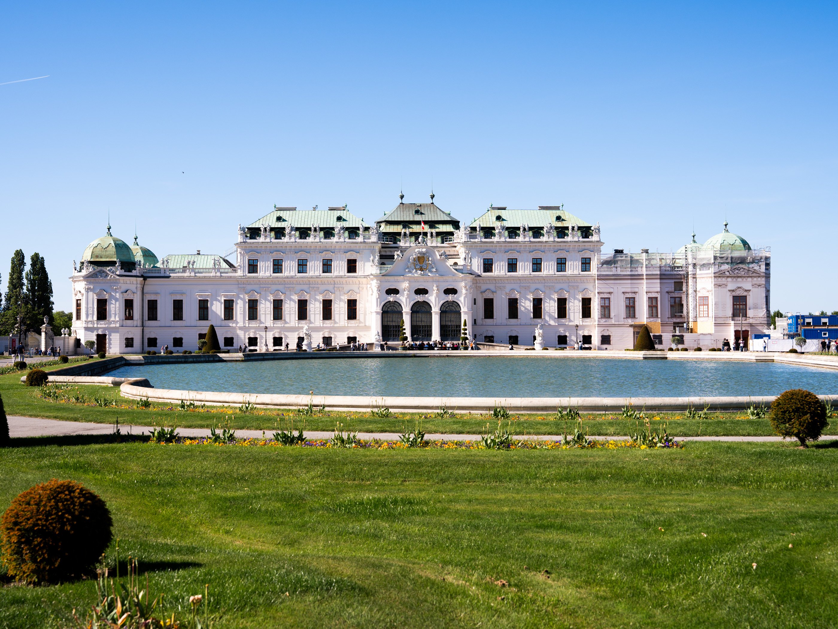 Le palais du Belvédère de Vienne de style baroque, son vaste étang et son jardin sur fond de ciel bleu par une journée ensoleillée.