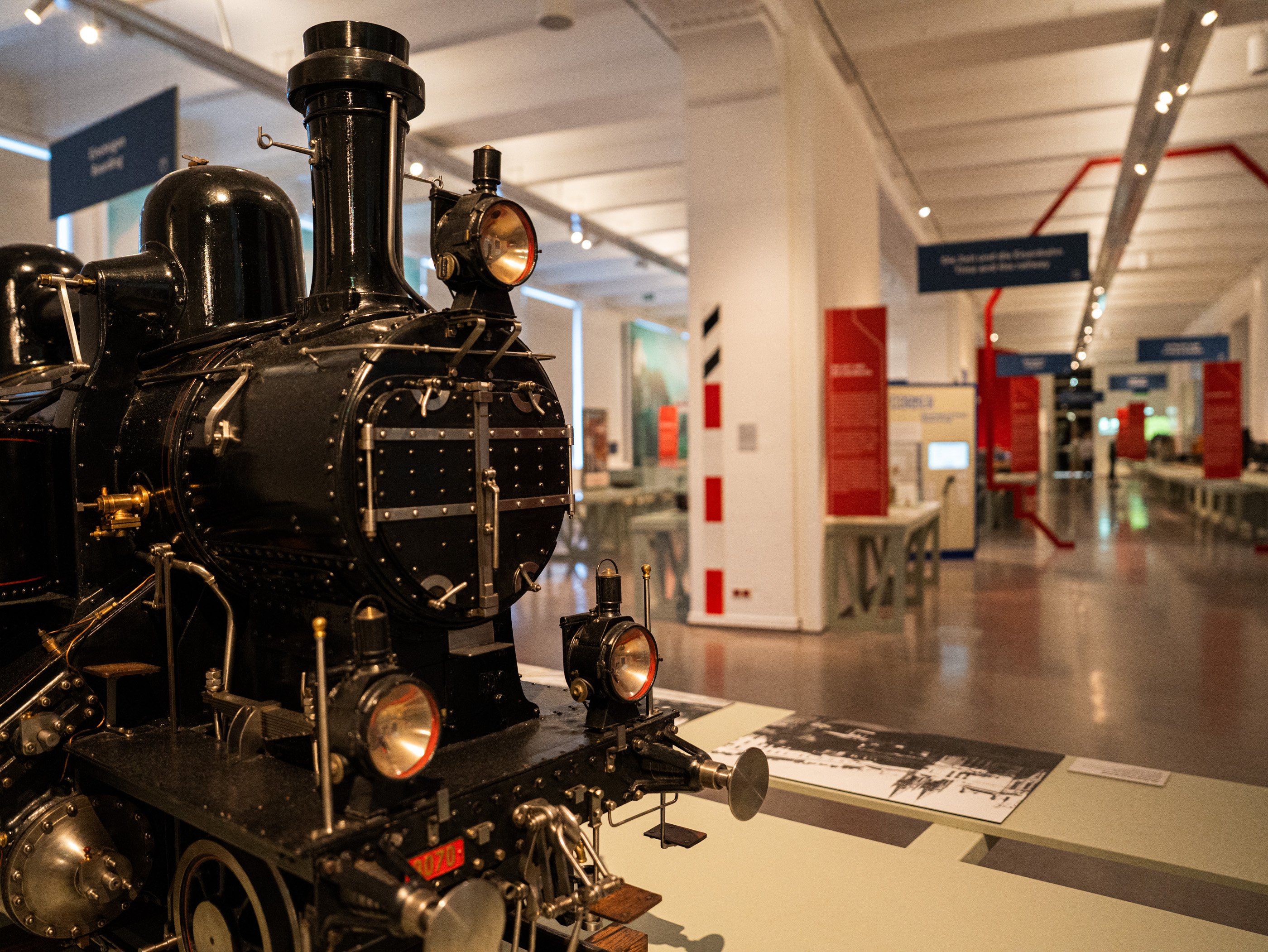 Une locomotive à vapeur miniature noire dans une salle d’exposition du Technisches Museum Wien.
