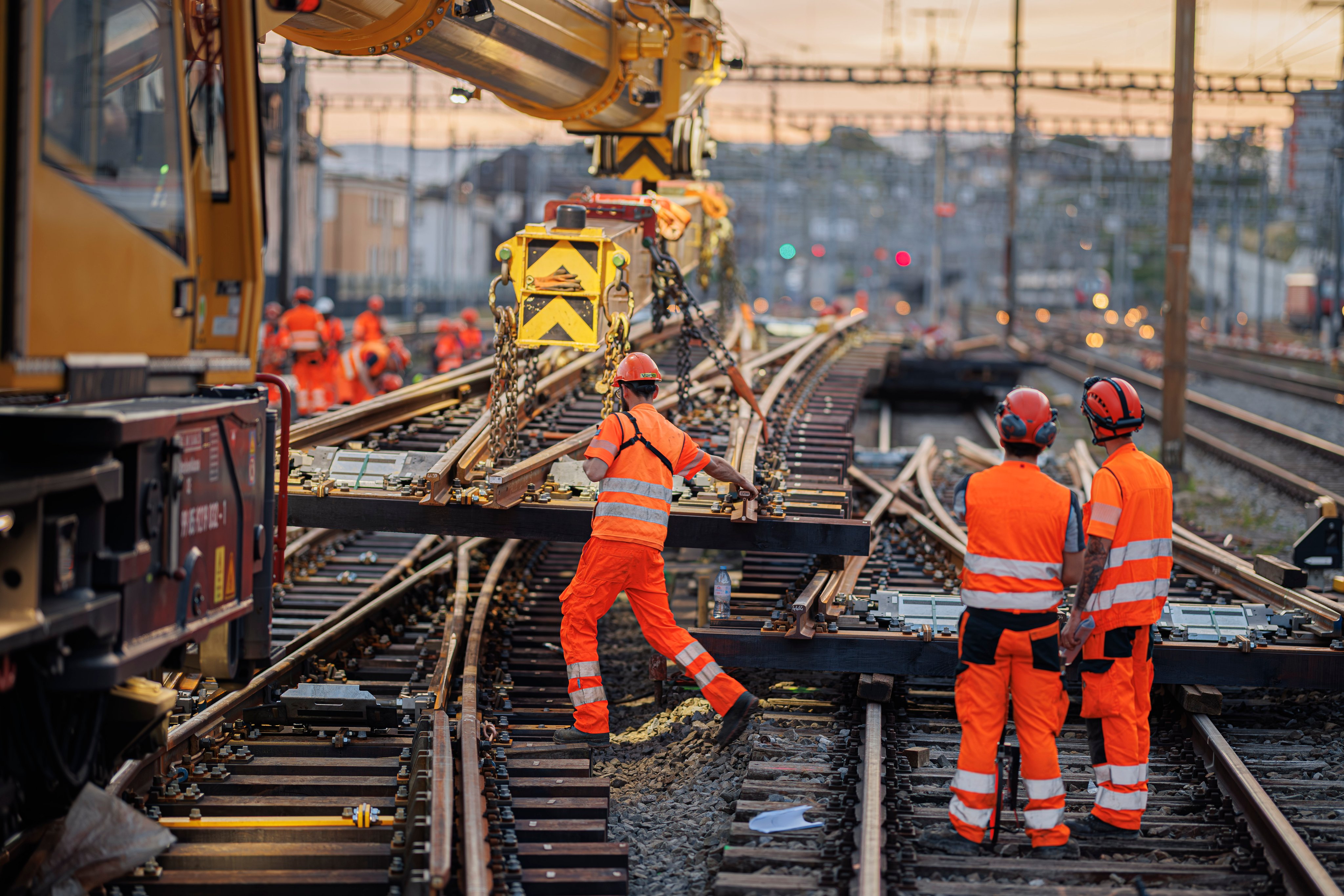 une grue pose des aiguillages en gare