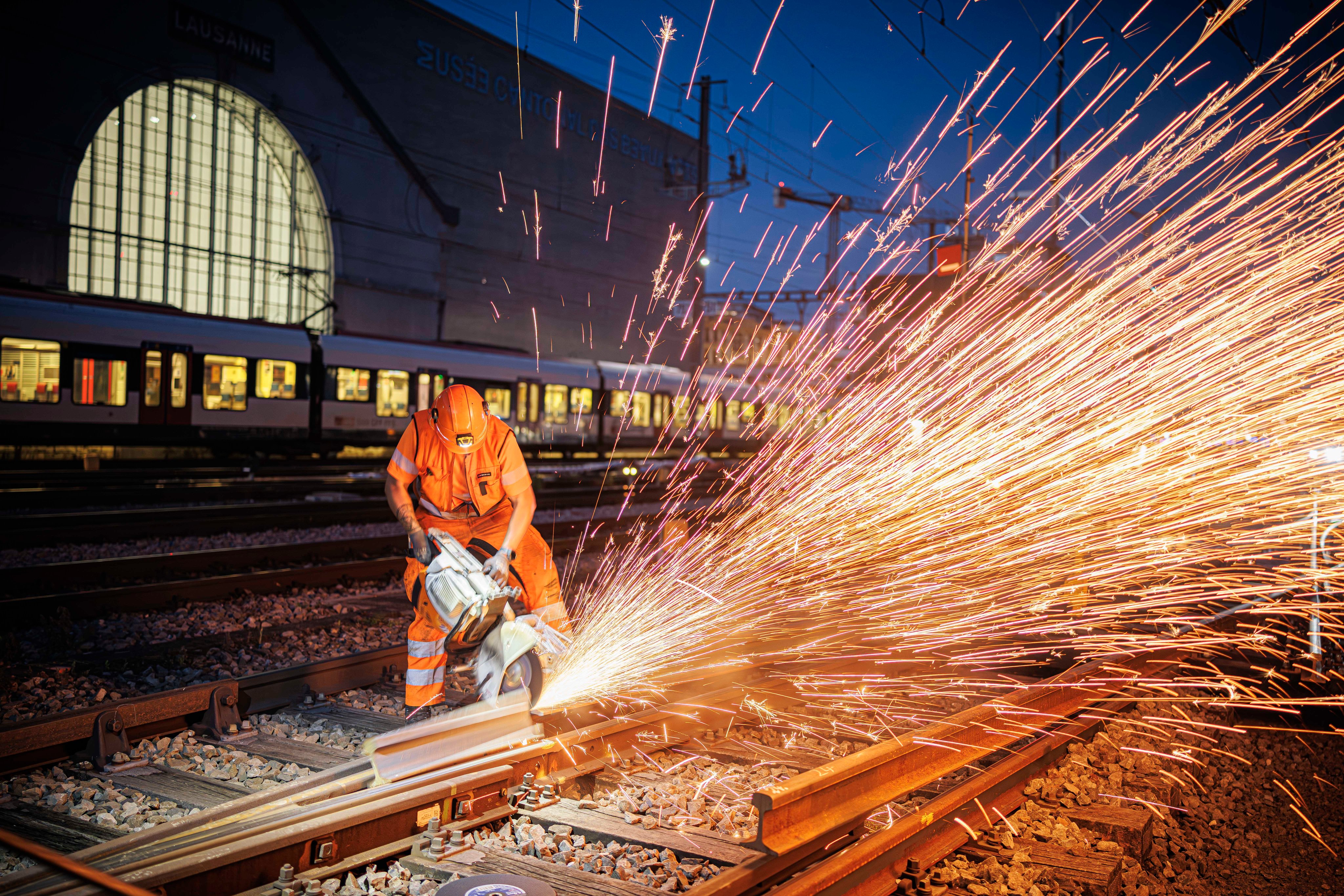 ouvriers sciant des rails, étincelles