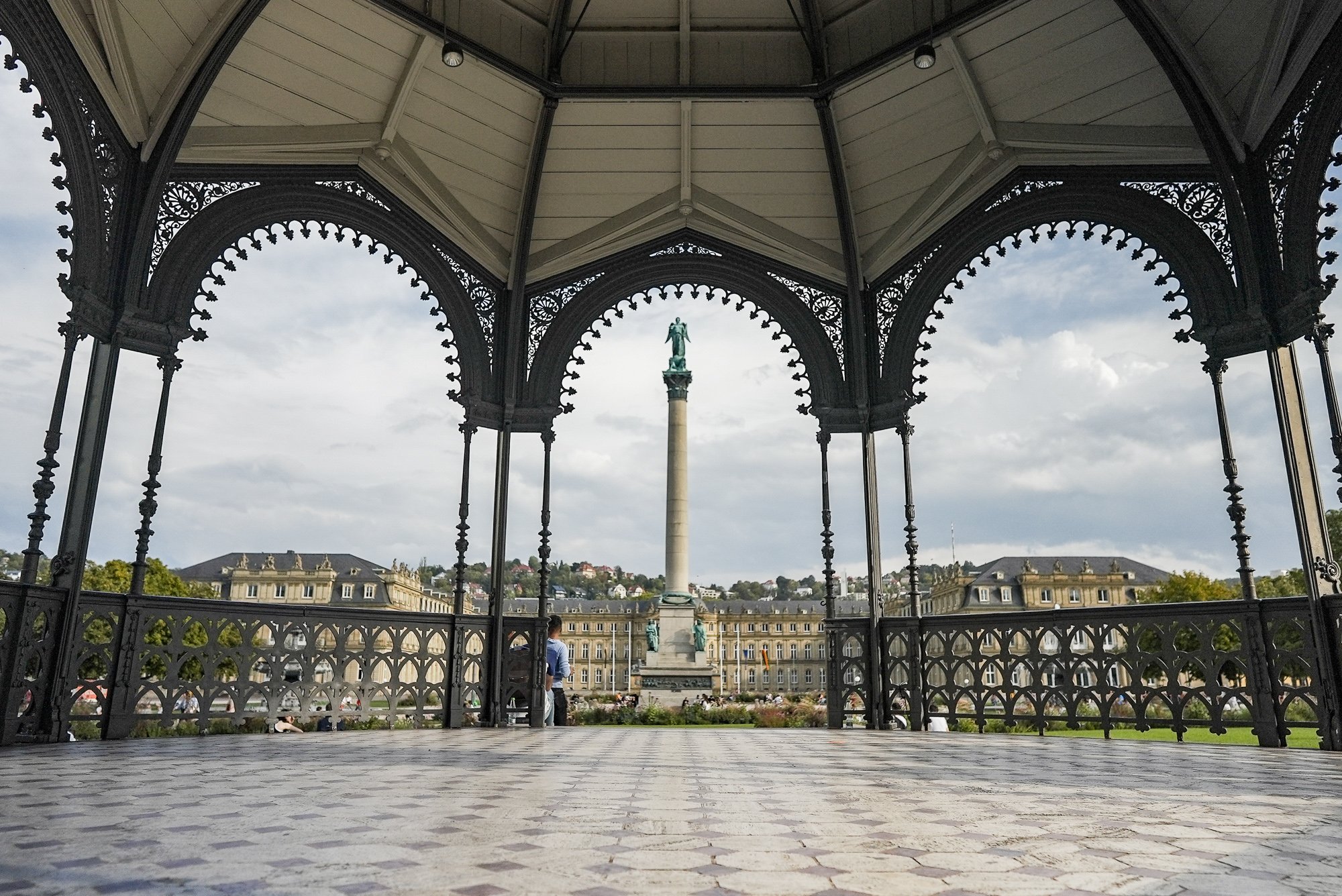 Sicht aus einem Pavillon auf eine längliche Statue vor dem Neuen Schloss.