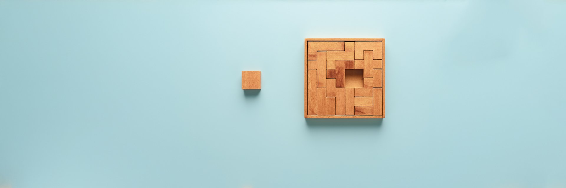 A wood block puzzle with one final piece floating into place. 