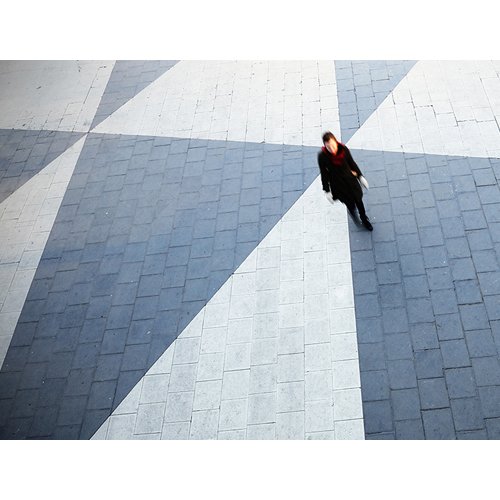 A boldly colored pattern with asymmetrical shapes on a brick walkway
