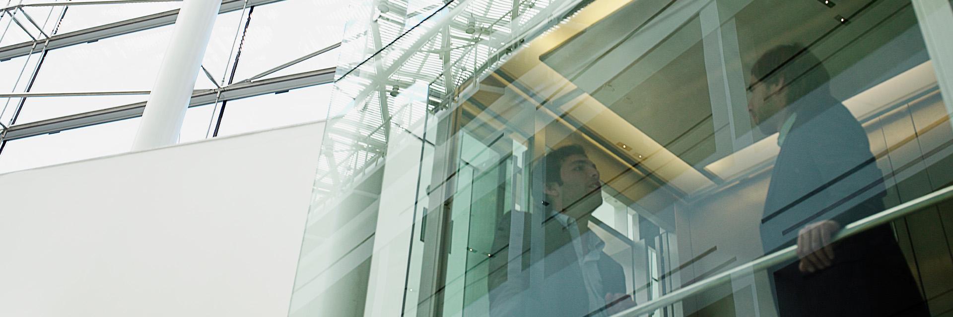 Two people talking behind modern building