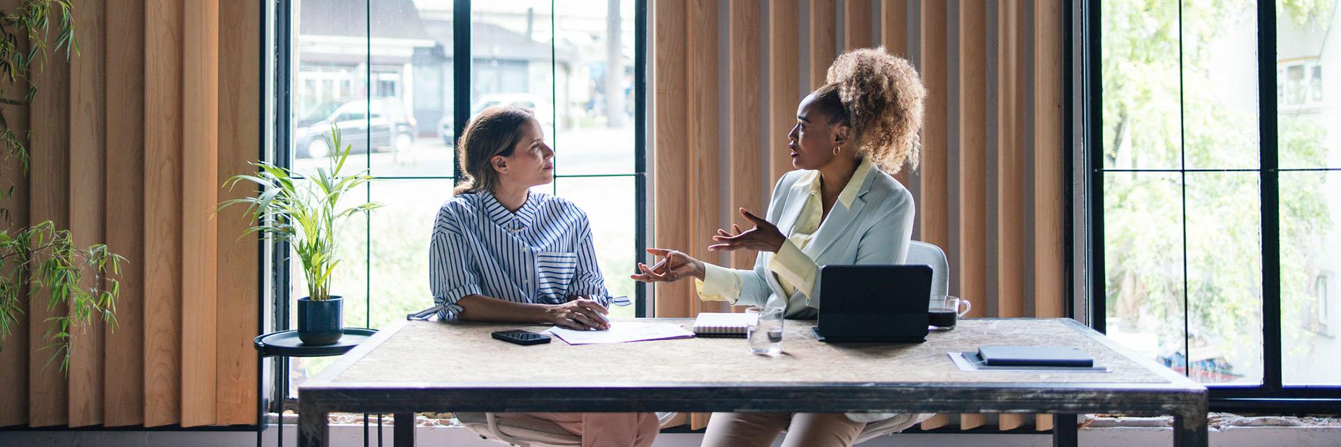 two-people-talking-at-desk