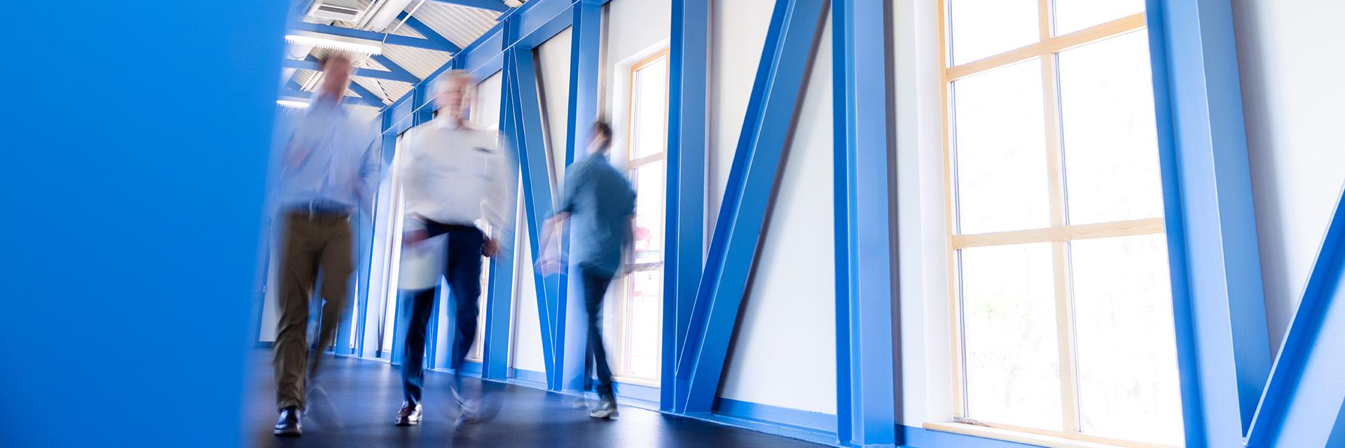 People walking through a modern building hallway