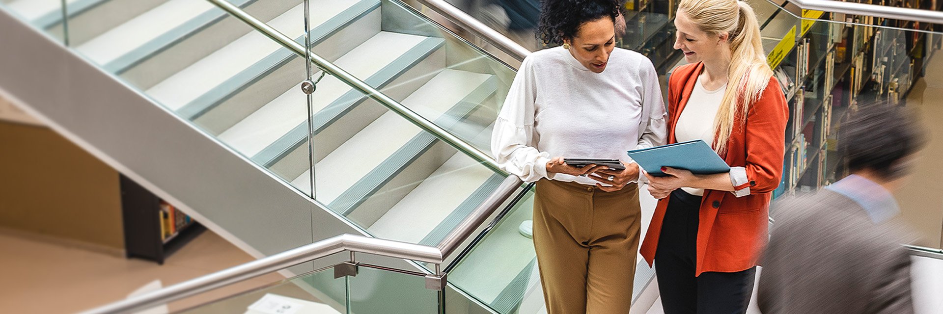 Two people looking at a portfolio together in a modern building