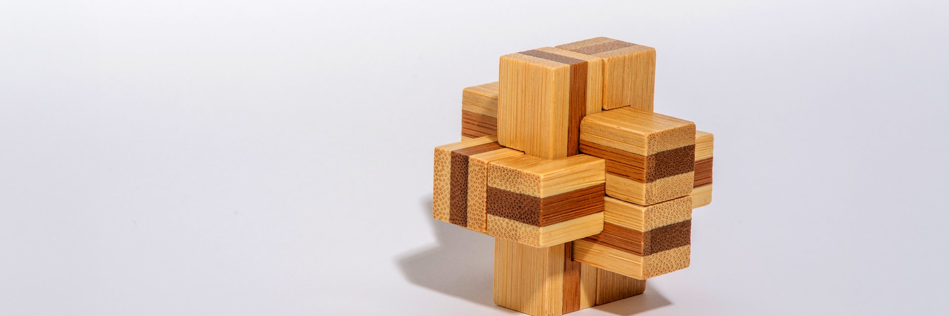 A wooden block puzzle against a plain background