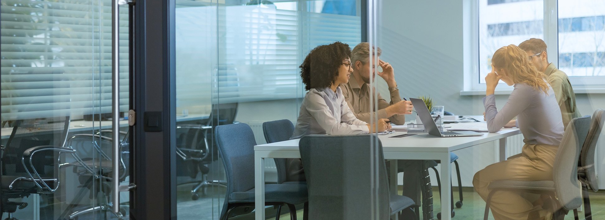 Professionals meeting in a modern glass office.