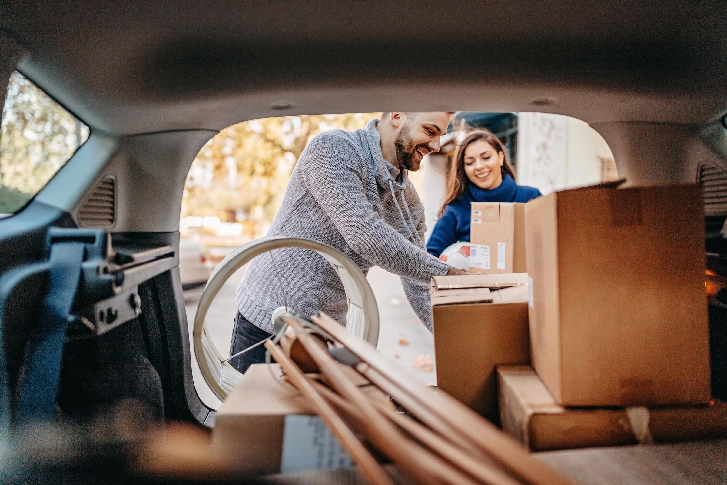 Young couple packing a car with moving boxes.