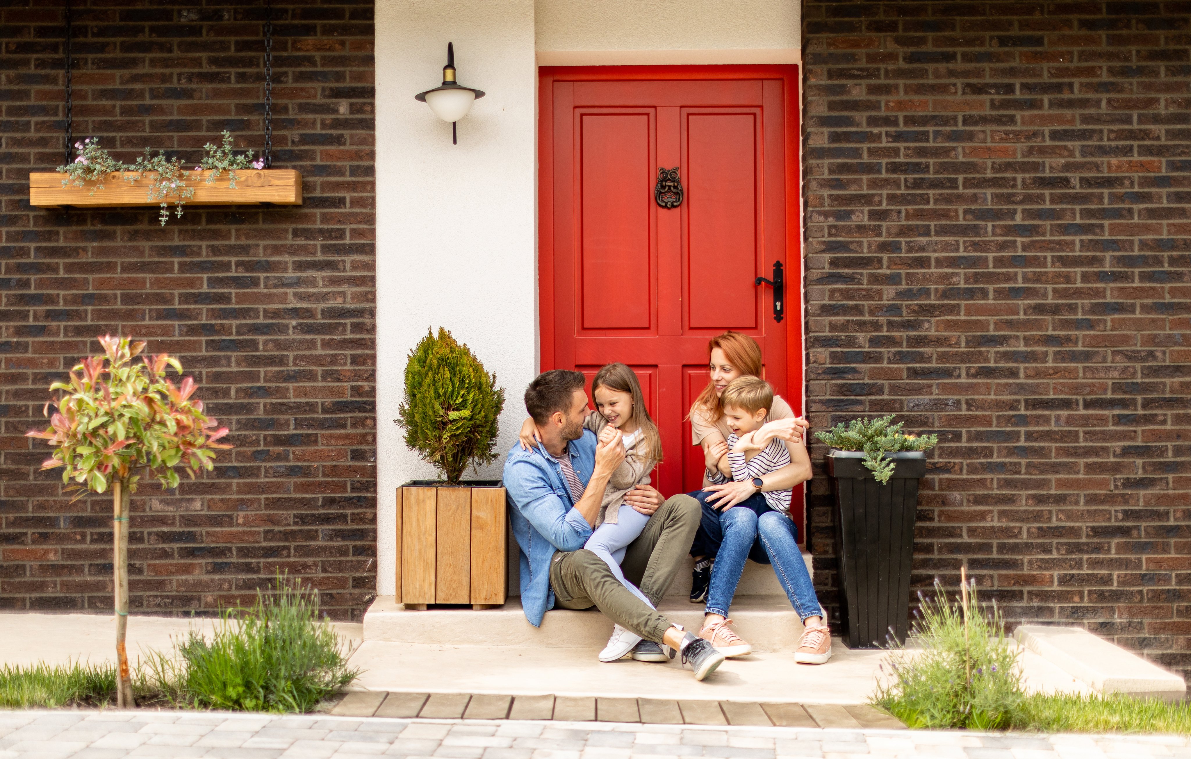 Family of four sat outside of their house chatting