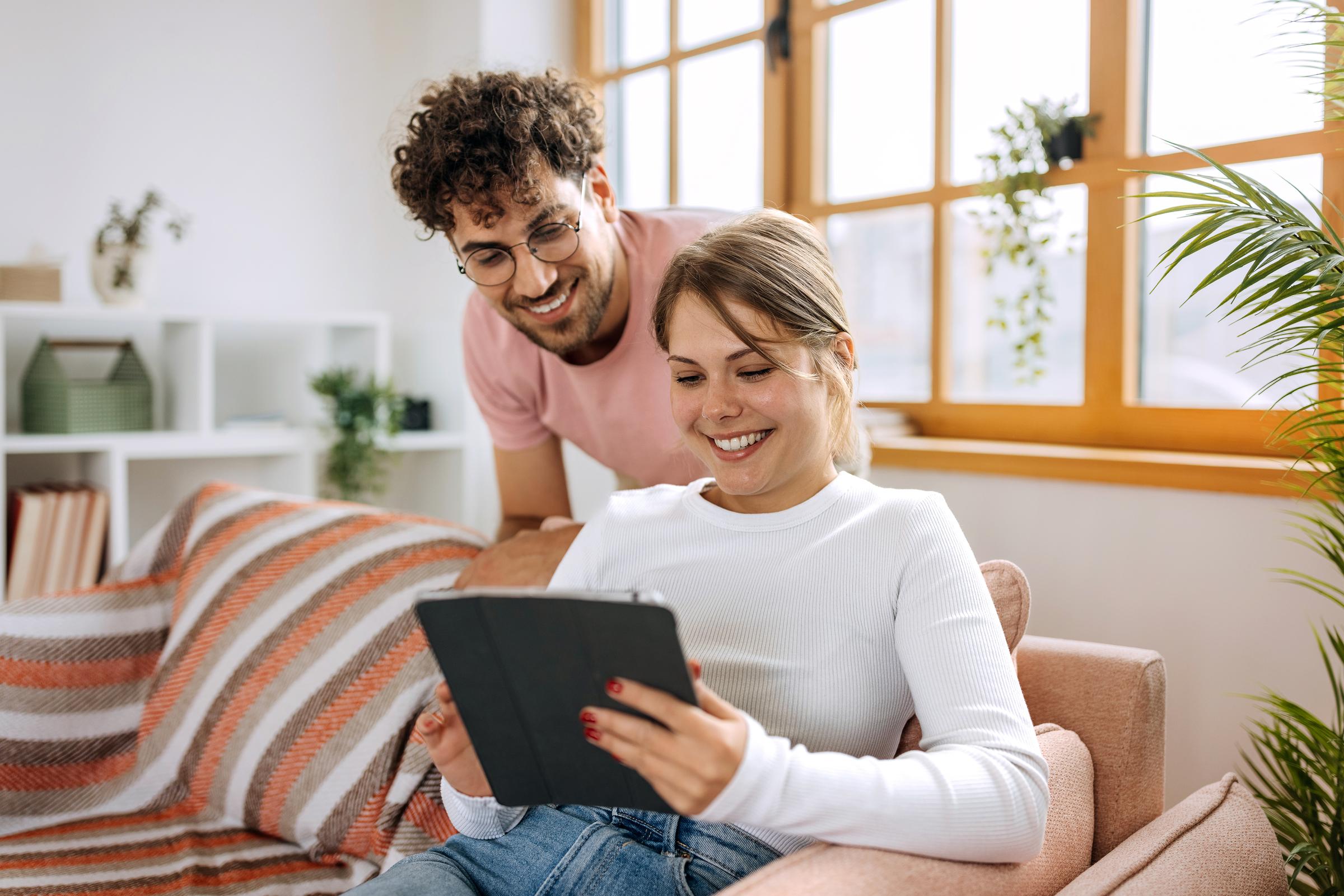 Young couple using digital tablet together at home