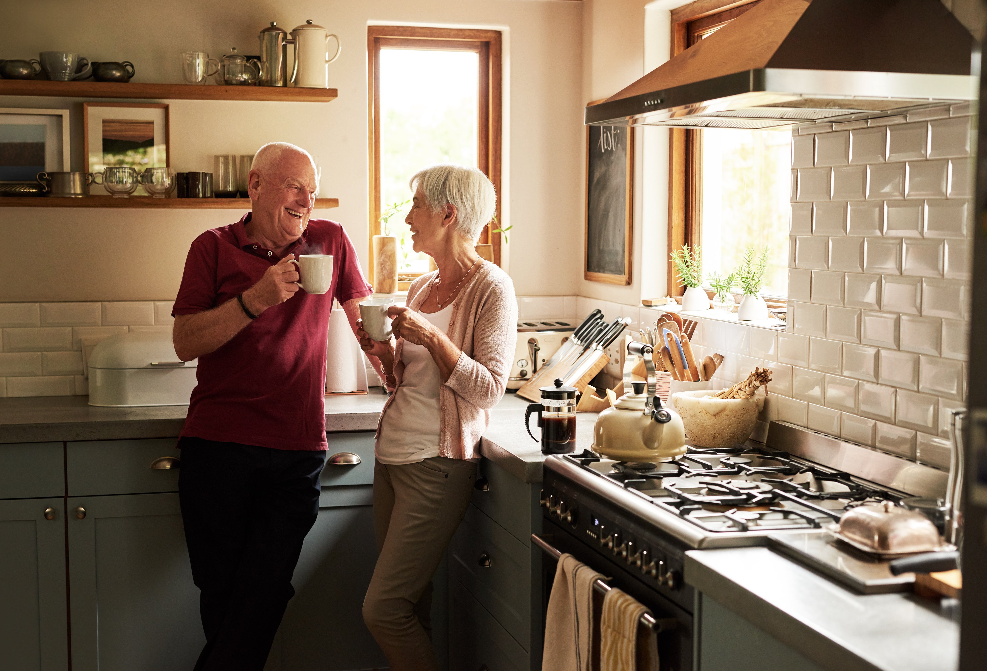 elderly couple drinking tea in their kitchen