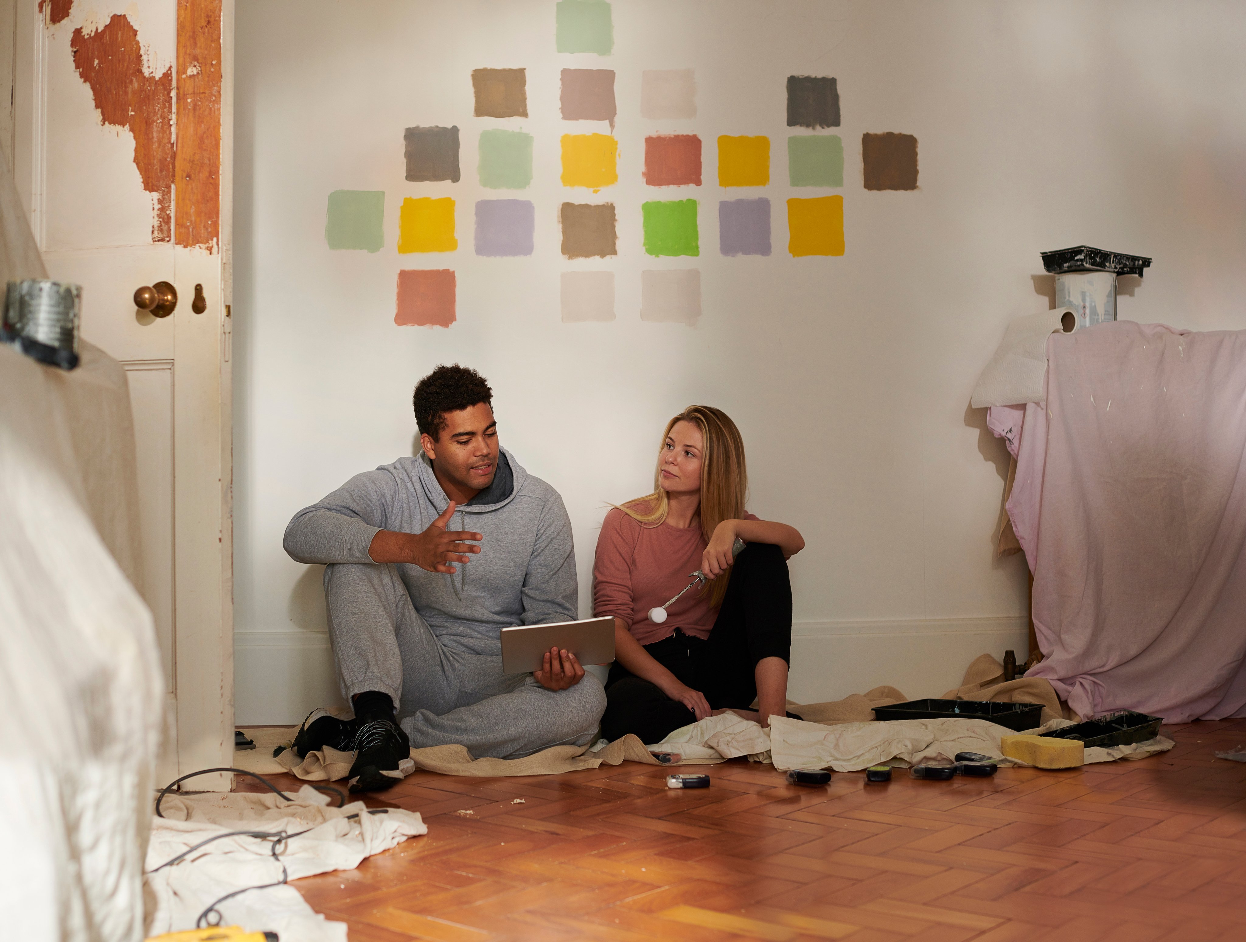 A couple look at an ipad while picking paint colours