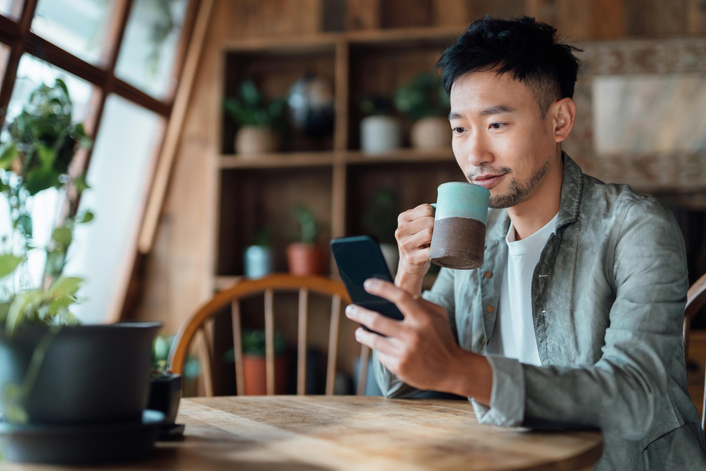 Man manages online banking on smartphone at home