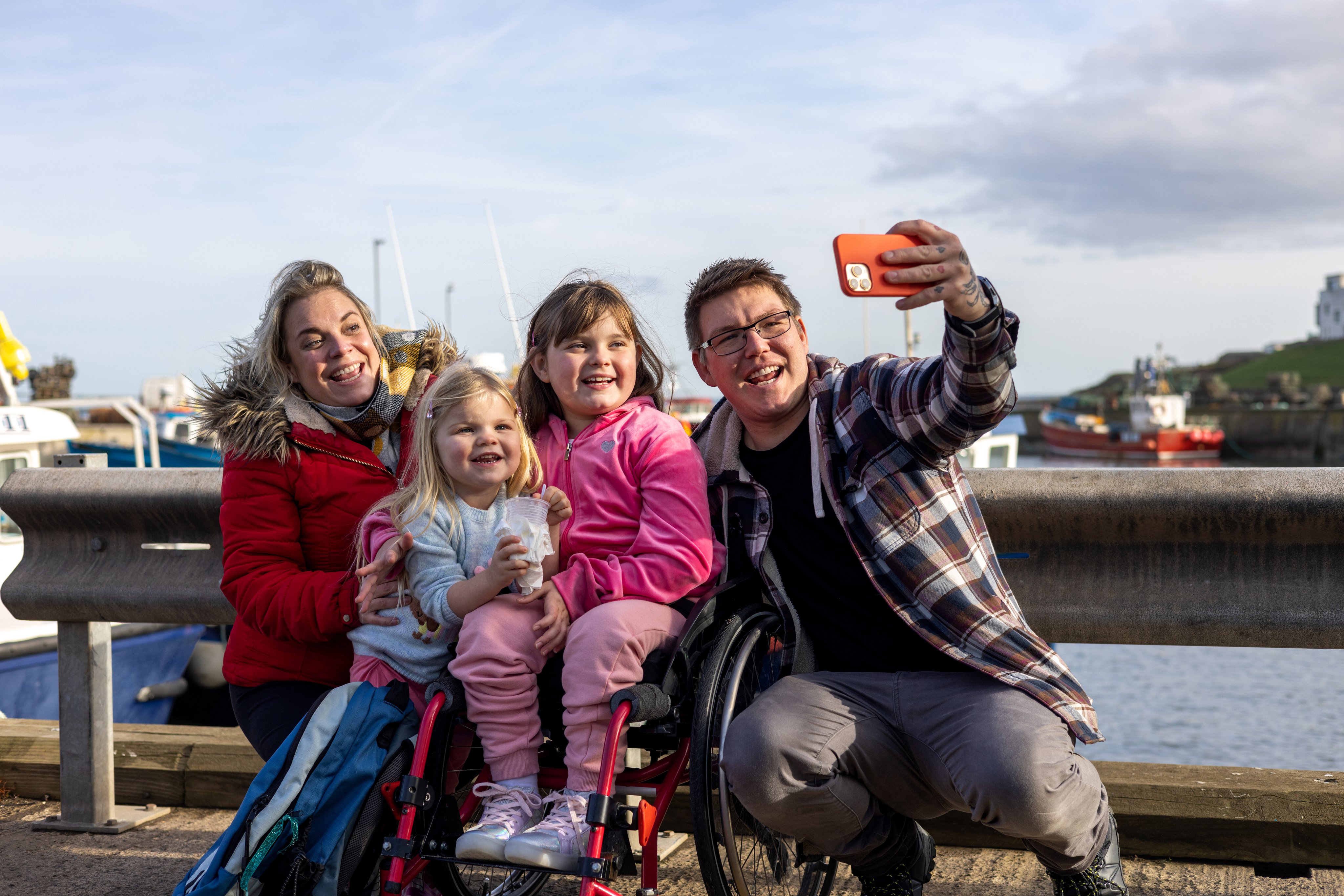 Family with two children, including wheelchair-using daughter, take selfie 