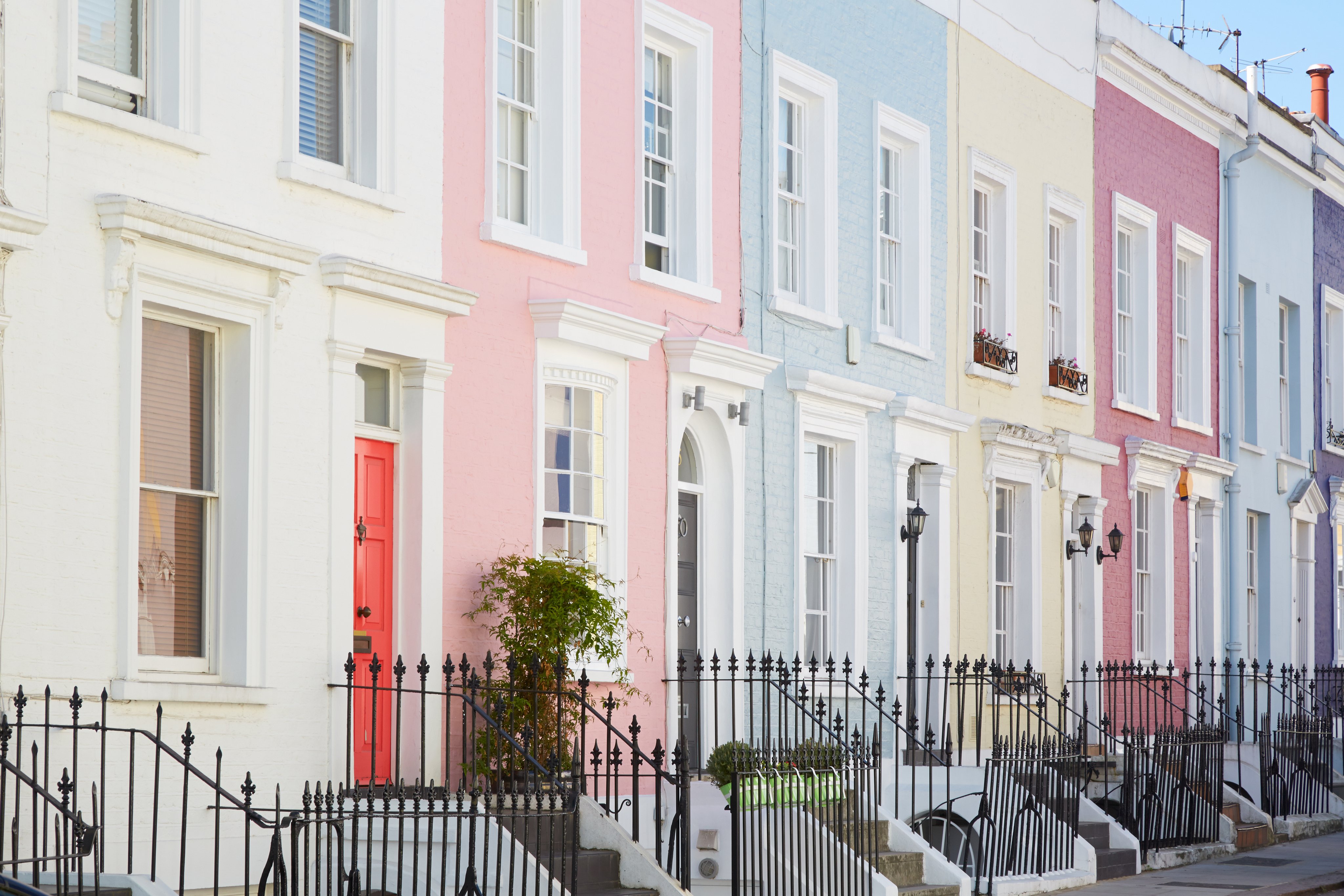 Colorful English houses facades in a row, pastel pale colors