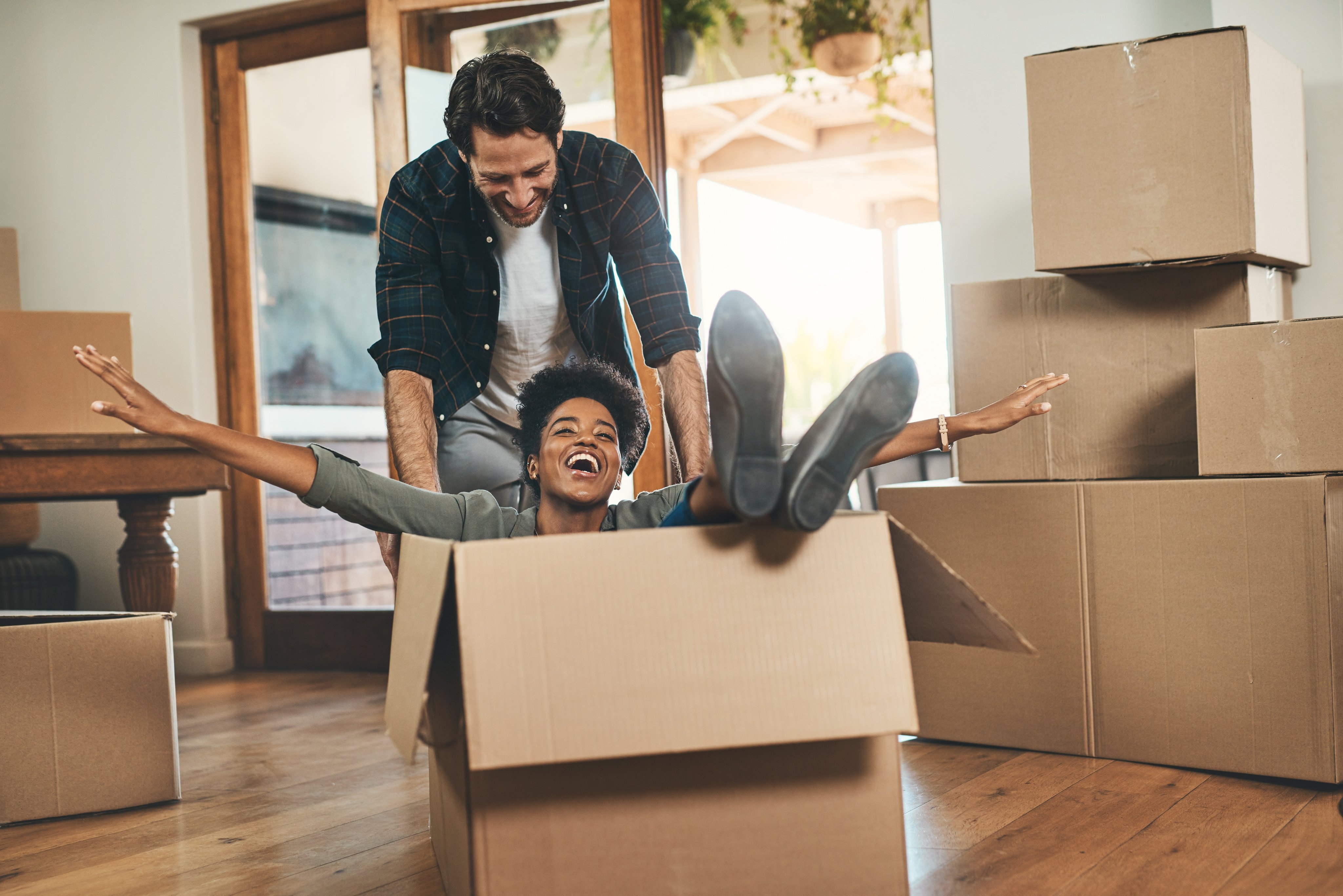 A happy couple celebrate moving into their new home, surrounded by boxes
