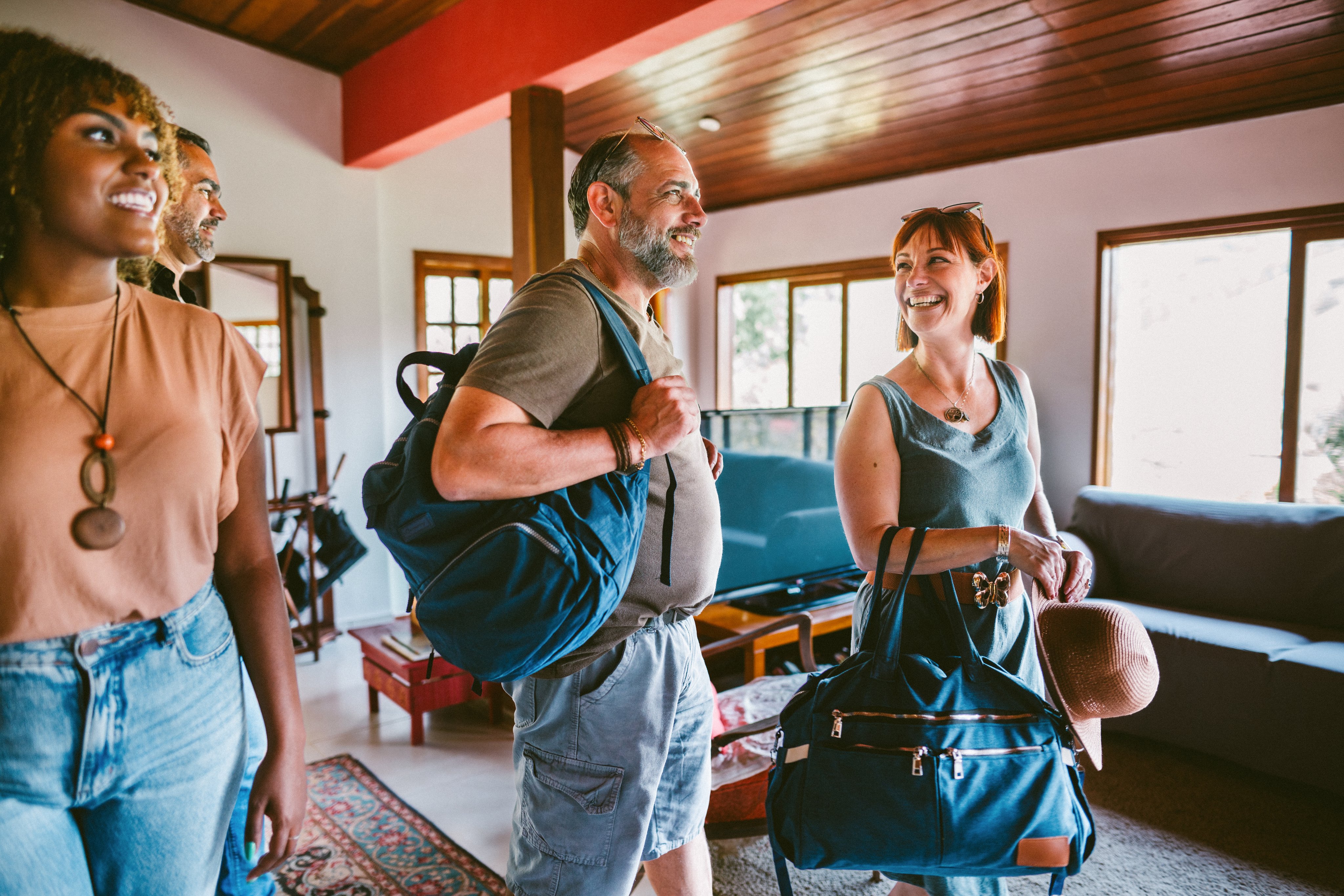 Mature couple arrive at vacation home with bags