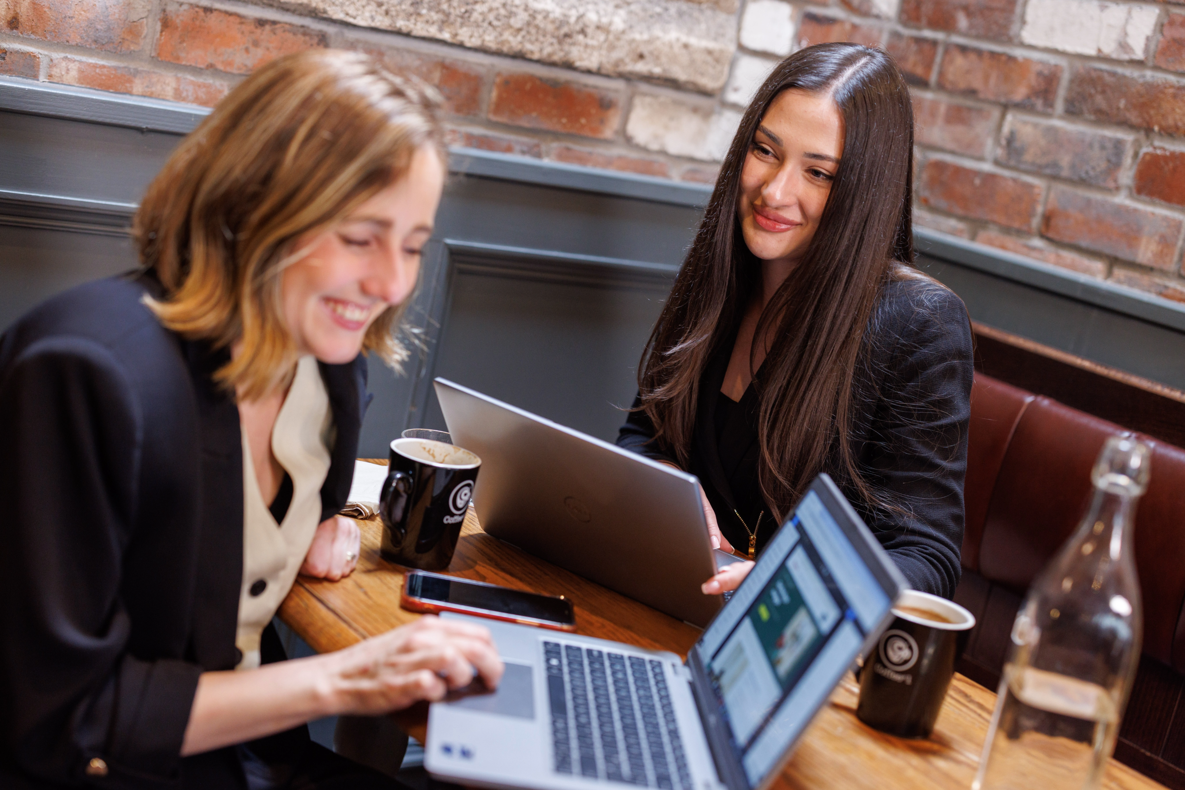 Two women working together and smiling at each other