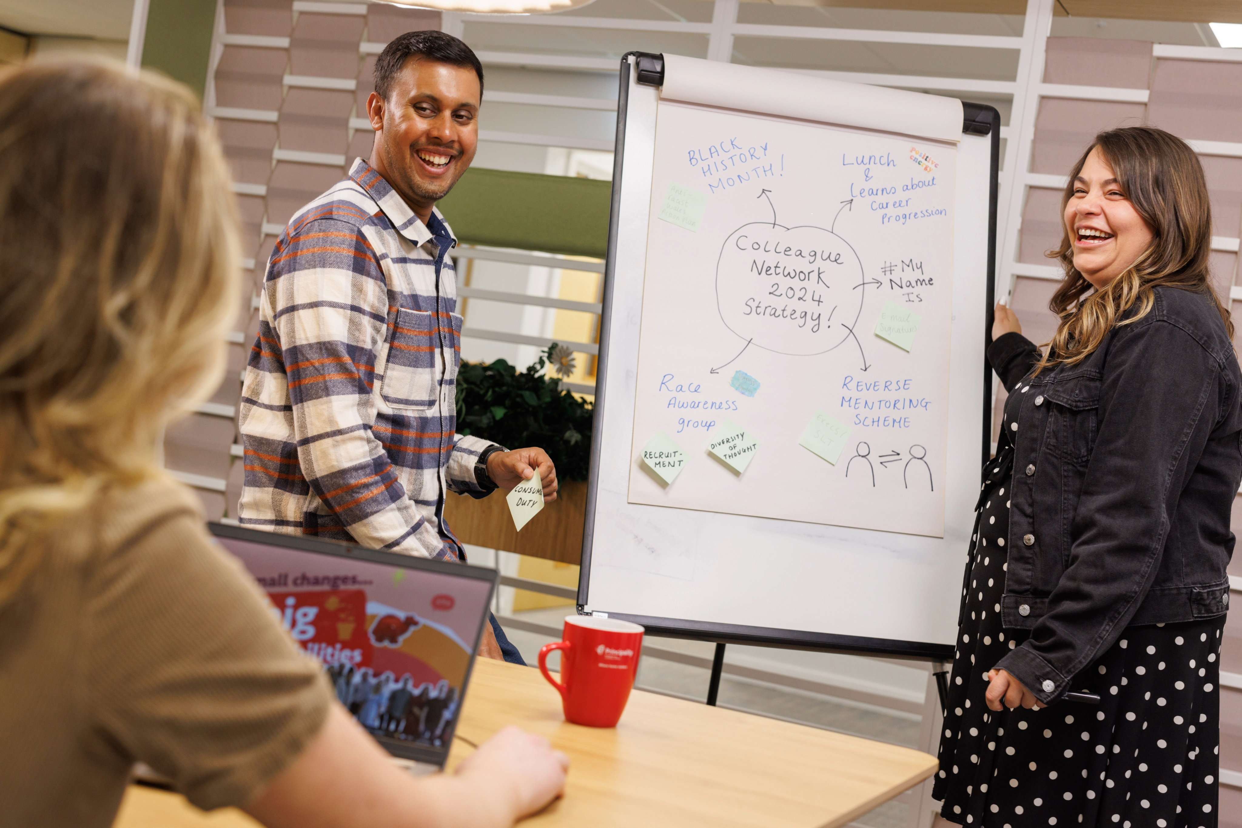 A man and a woman are laughing in a work setting