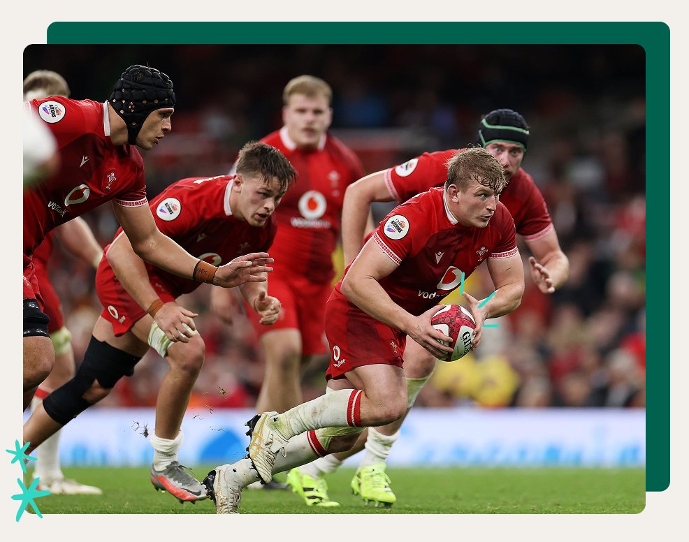 Welsh rugby players running with the ball during a match