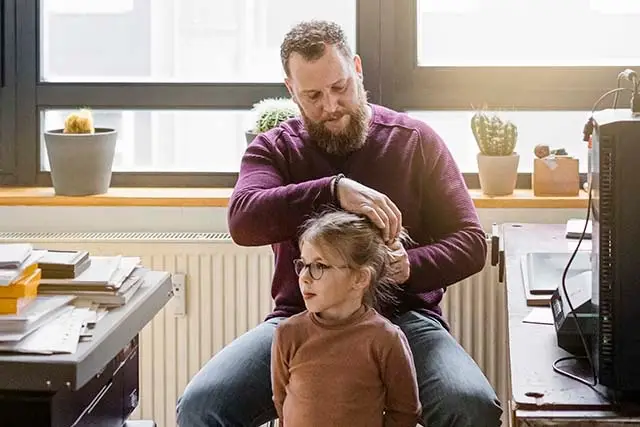 Vater macht seiner Tochter die Haare