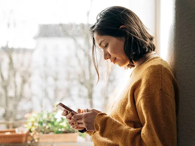 Frau schaut konzentriert auf ihr Smartphone