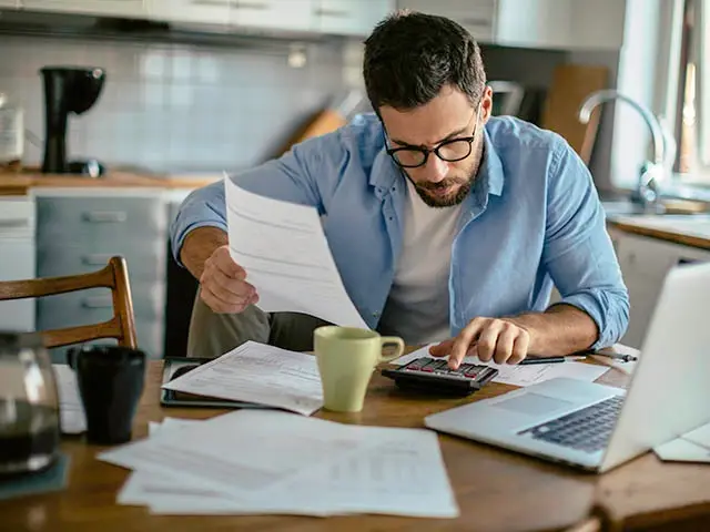 Frau arbeitet an Kücheninsel mit Handy