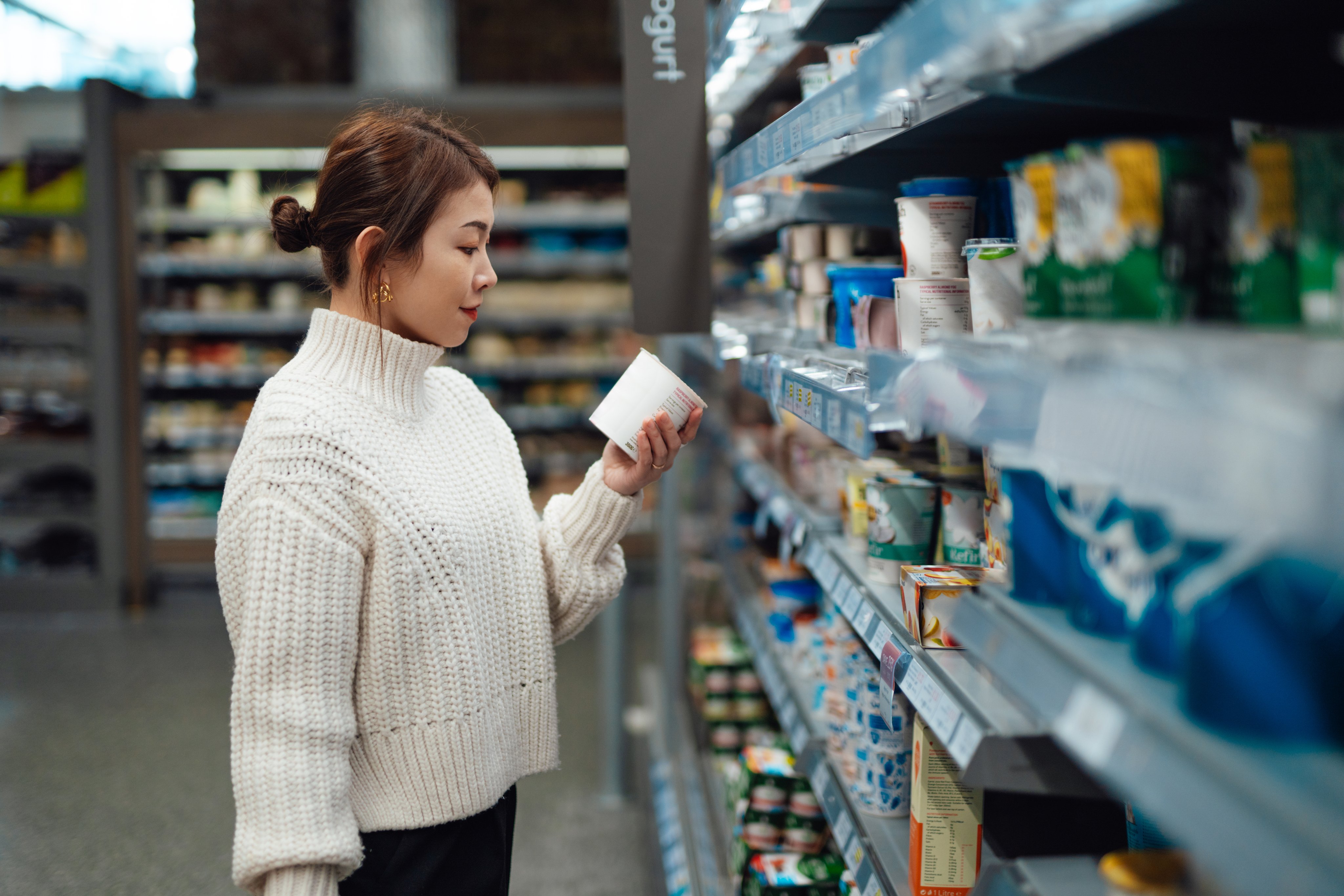 A young woman looking at supplements at the store.