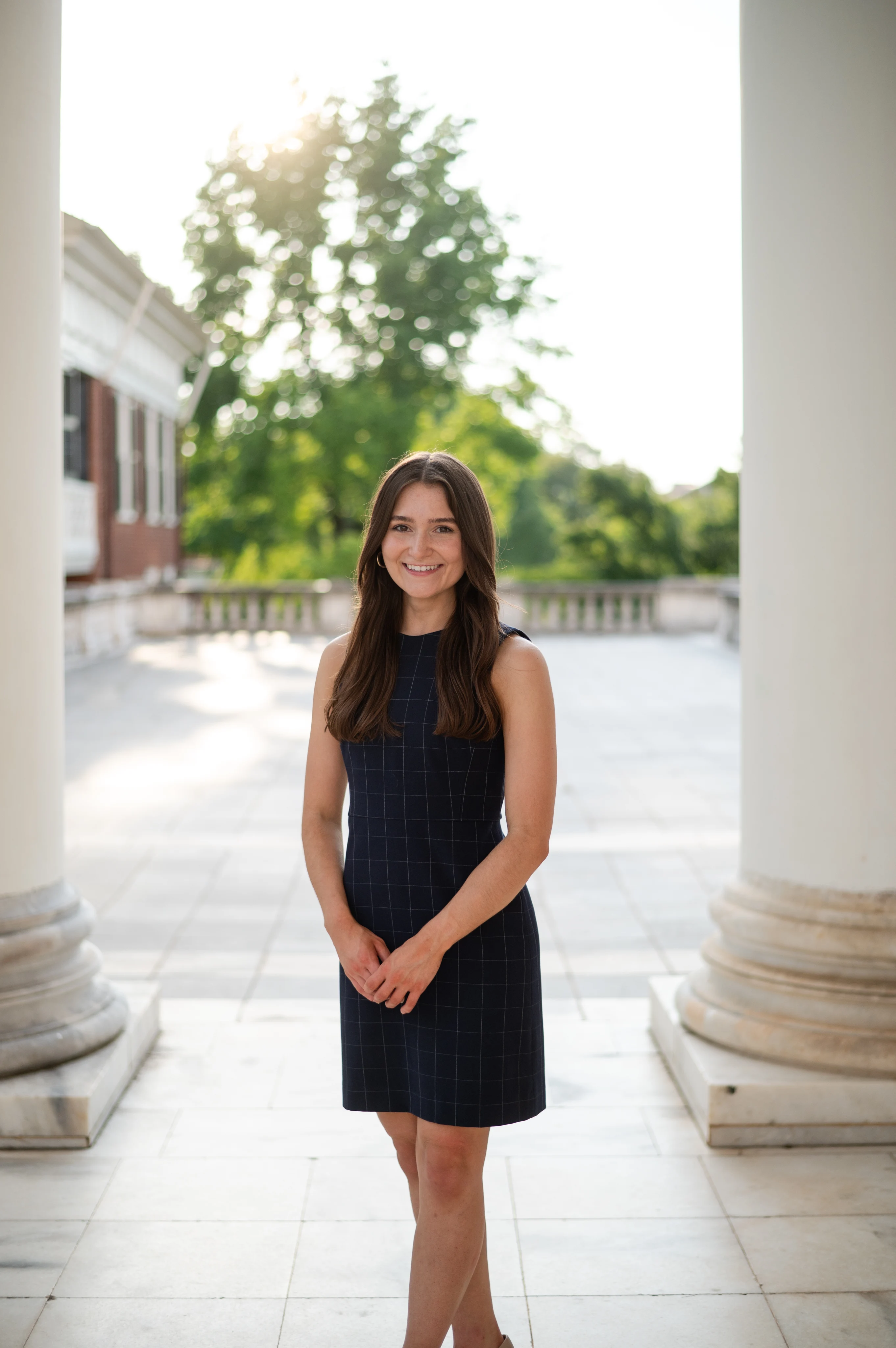 Rachael Kral, a cardiology pharmacy resident, poses at UVA between the rotunda's pillars