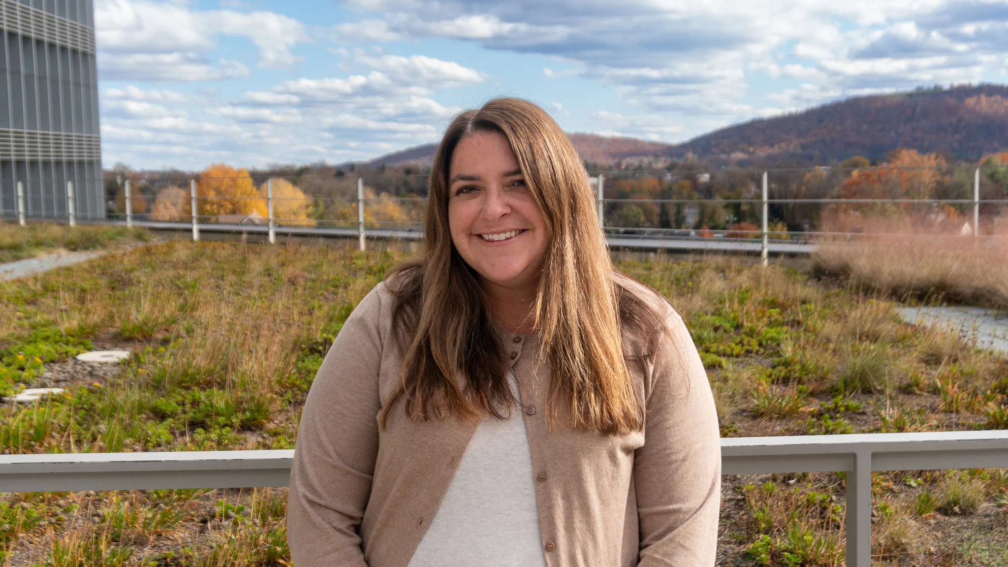 Jennifer walters stands atop UVA Health with mountains in background