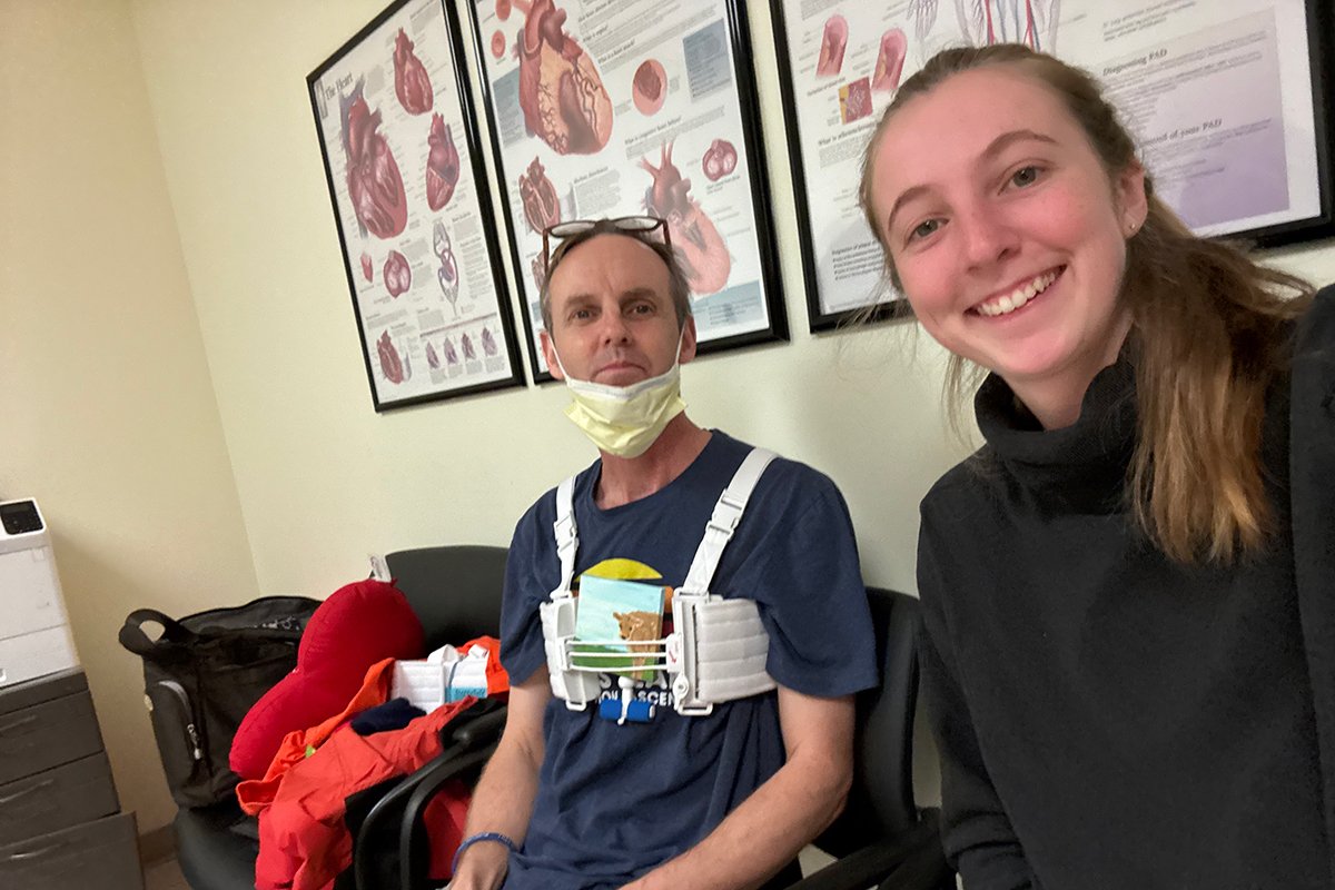 Mark Lepsch, MD, sitting with a family member and wearing a chest harness