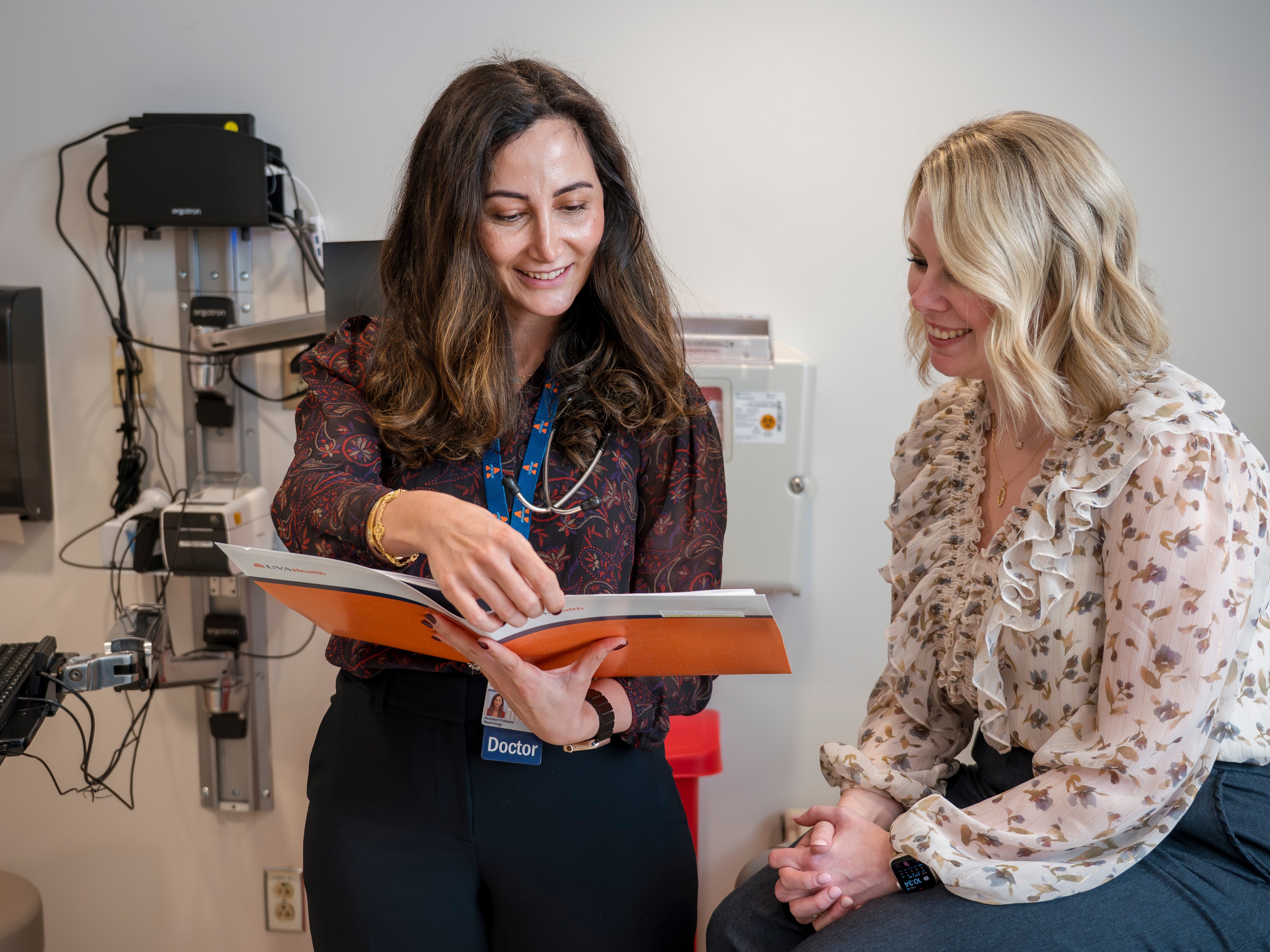 A UVA Health kidney transplant provider lookin at some paperwork with a patient