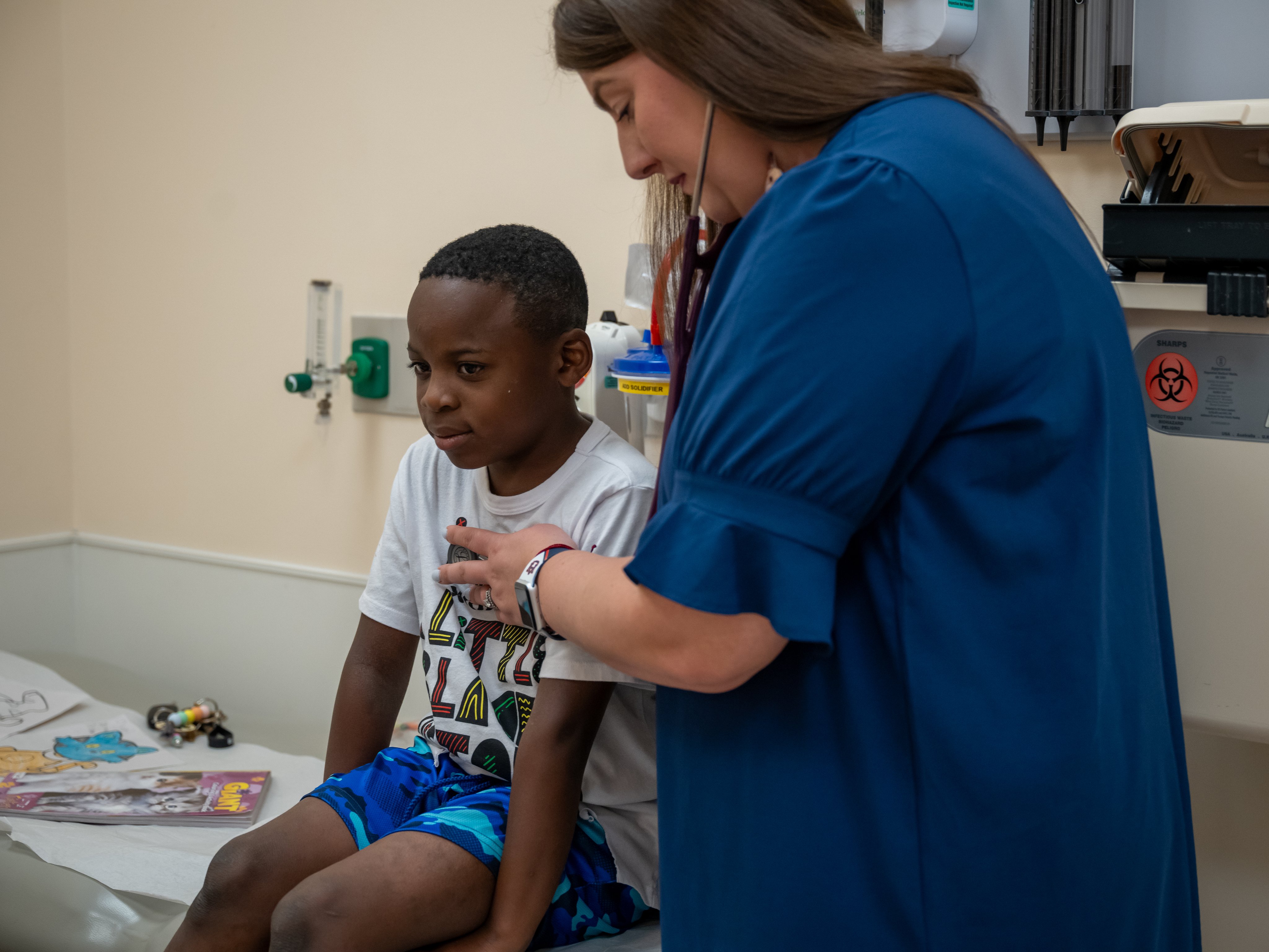 Brittany Wall, pediatric pulmonologist, listens to a child's chest during appointment
