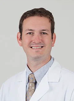 Dr. Jonathan Black in a white coat smiles at the camera