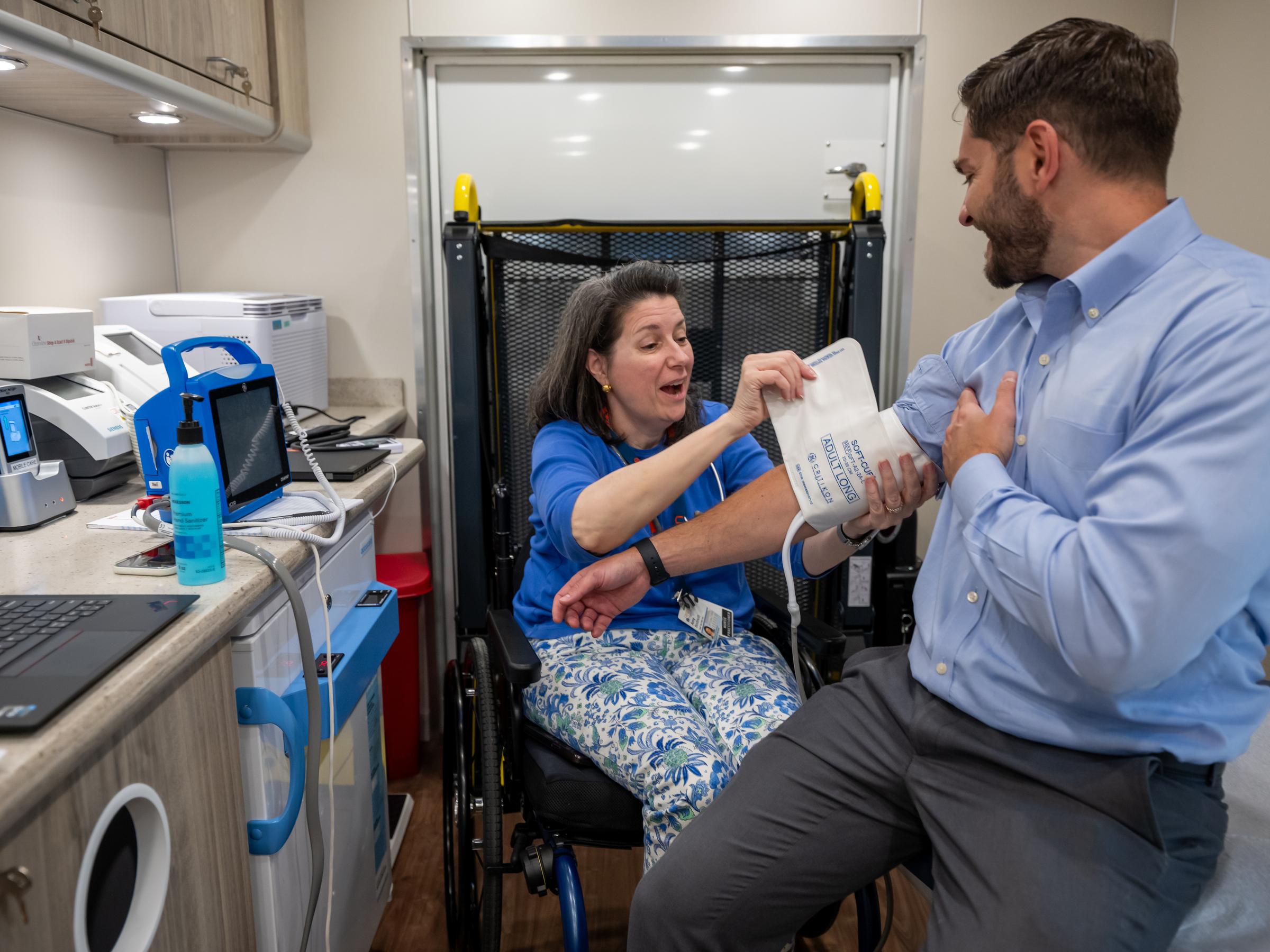 A healthcare provider putting a blood pressure cuff on a community member at an event