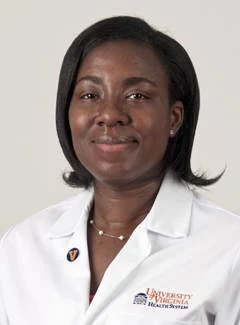 Dr. Adu-Darko in a white coat poses for the camera