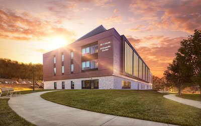 Large brick building captured at sunset with orange and purple sky in background