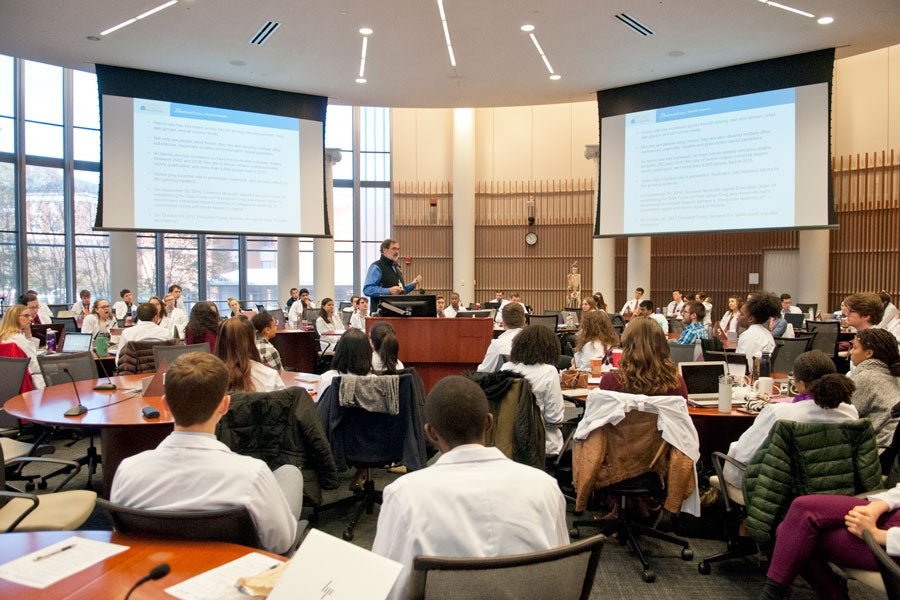 Students taking notes on laptops during a lecture