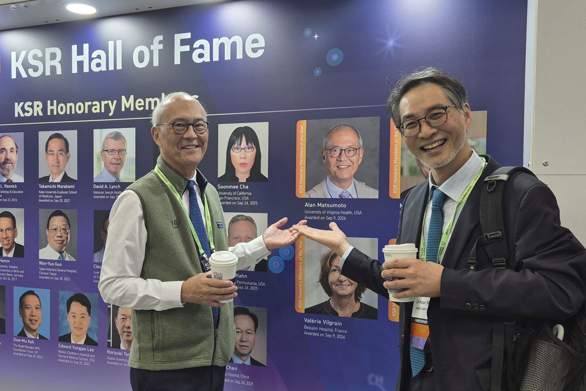 Dr. Matsumoto stands in front of Hall of Fame display.