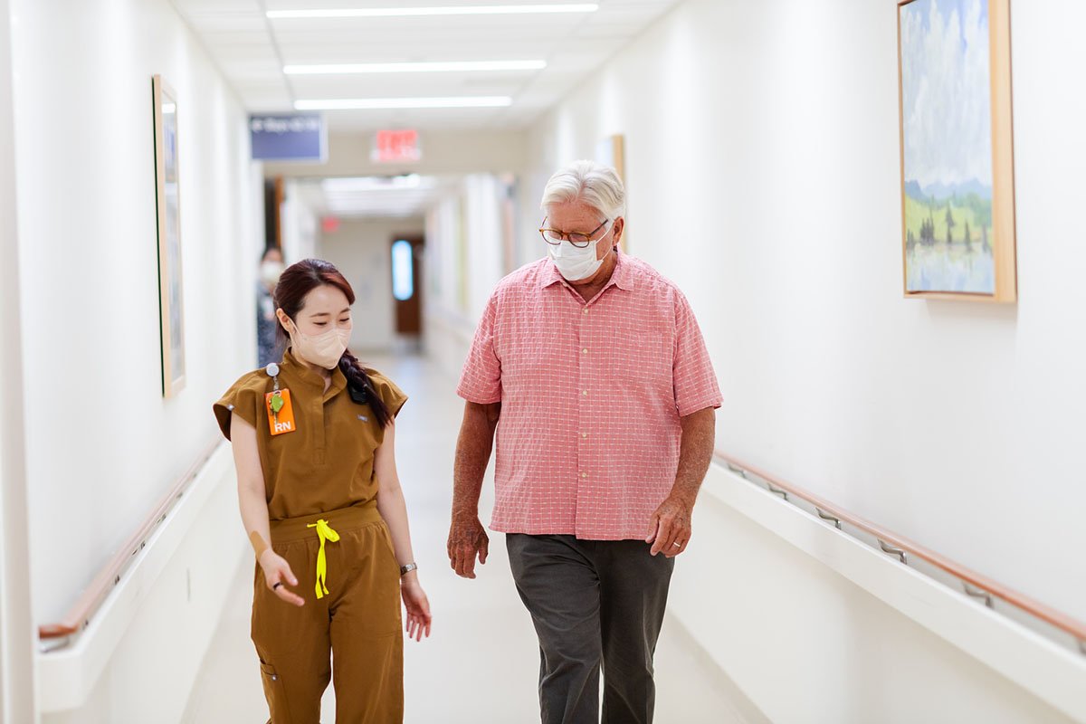 a provider walks down a hallway with a patient