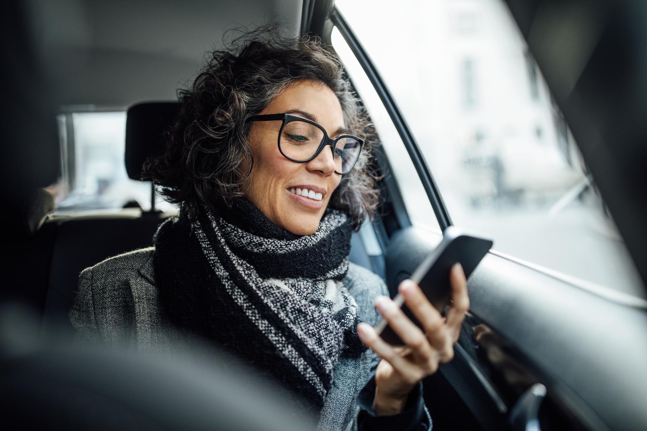 Woman in a car on a virtual visit with a doctor