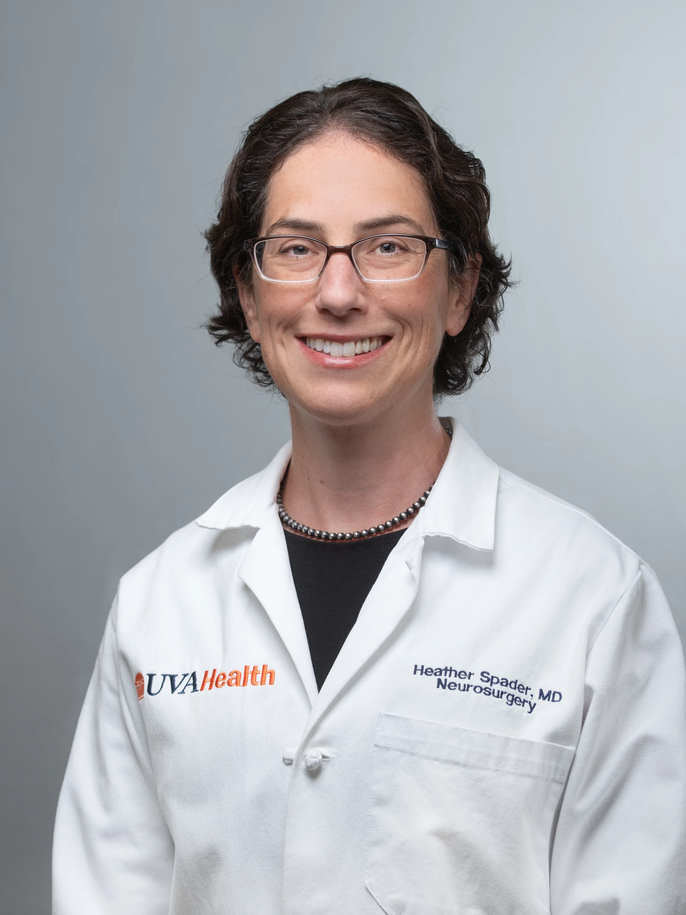 A headshot of Dr. Spader where she's in a white coat with glasses