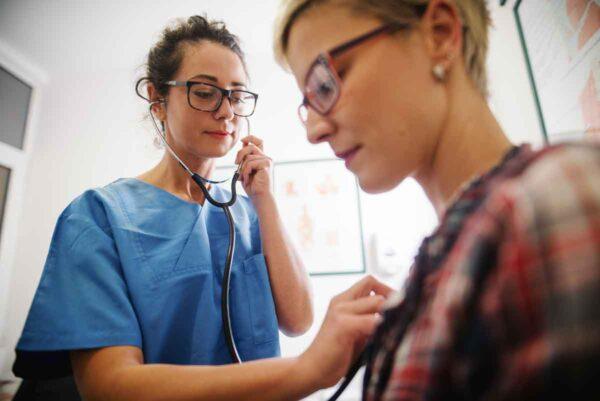 A provider using a stethoscope on a patient's chest