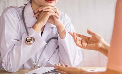 a woman listens to a doctor confirm her diagnosis during a second opinion consultation
